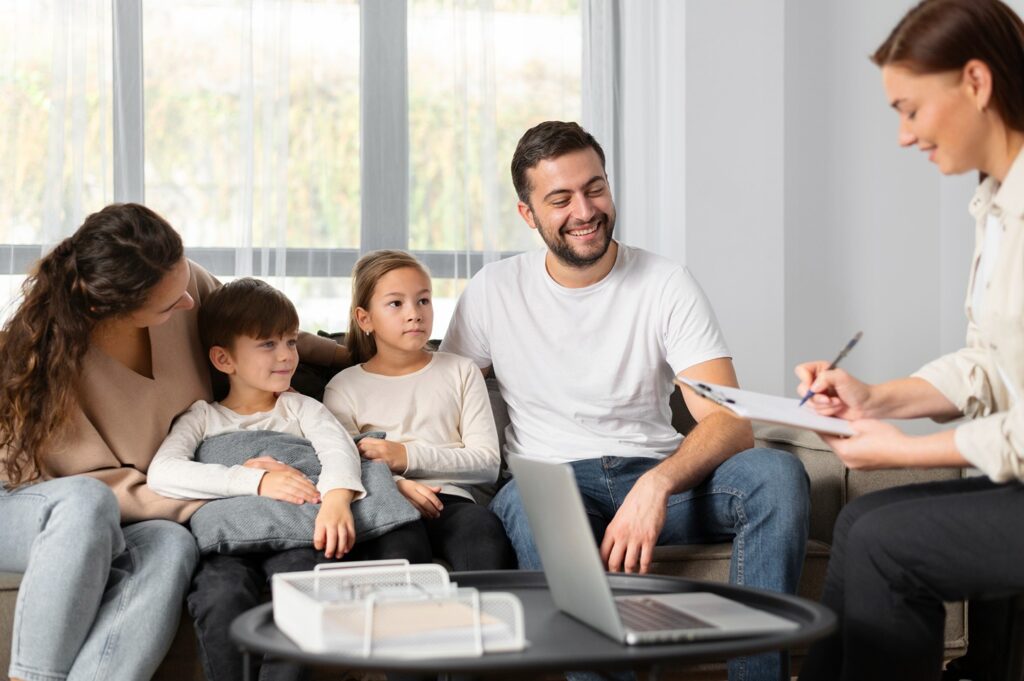 Family therapy session: Parents, children, and therapist talking. Mental health and well-being concept.