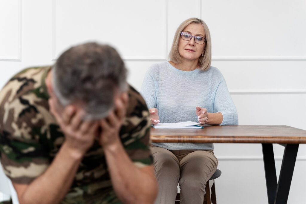 Trauma therapy: Soldier suffering from PTSD with psychologist. Mental health support for veterans.